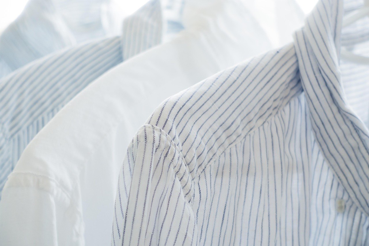Soft white and pale blue striped shirts on hangers