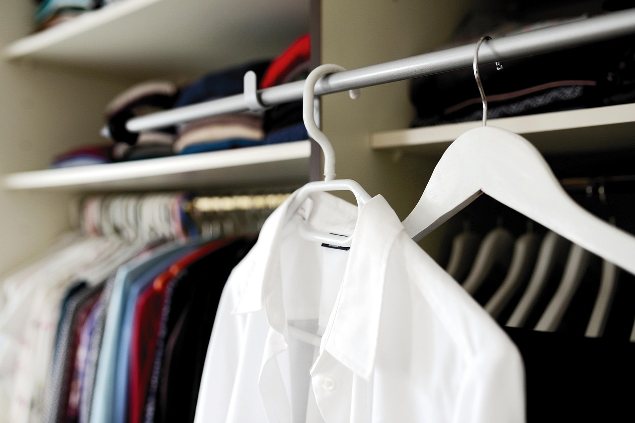 A crisp white shirt on a hanger in a wardrobe