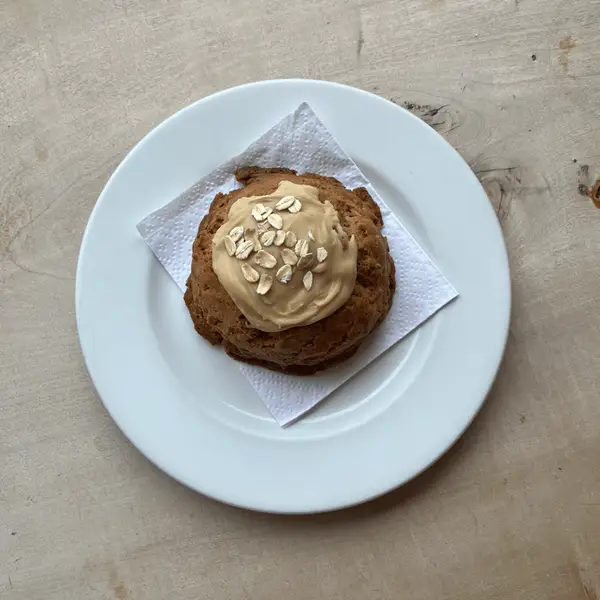 A glazed maple scone topped with oats
