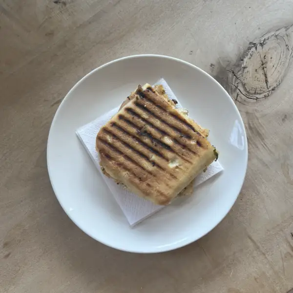 A grilled panini with grill marks on a white plate