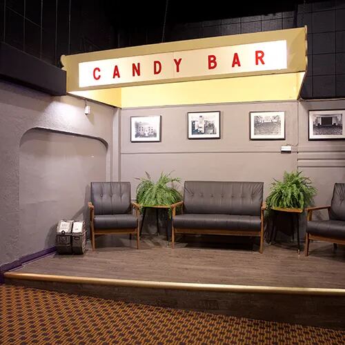The candy bar lounge with framed photos and a sofa
