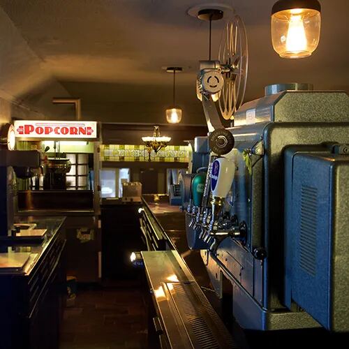 A vintage film projector beside the popcorn counter