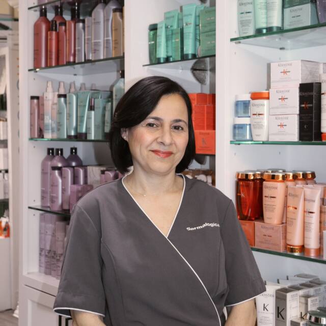 Connie, Esthetician, in front of the salon’s product wall