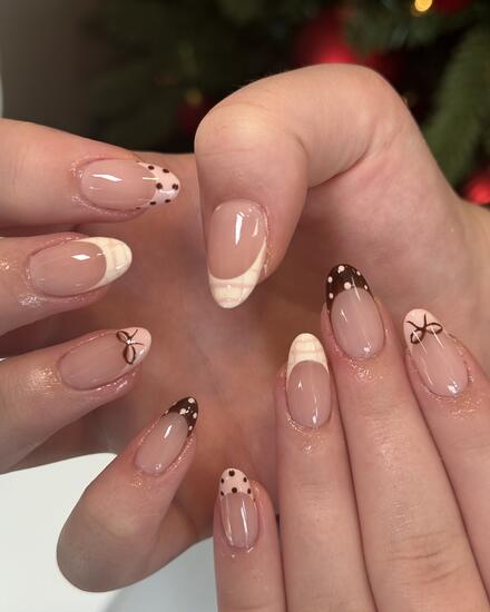 Nude almond nails with chocolate and cream French tips, polka dots and tiny bows