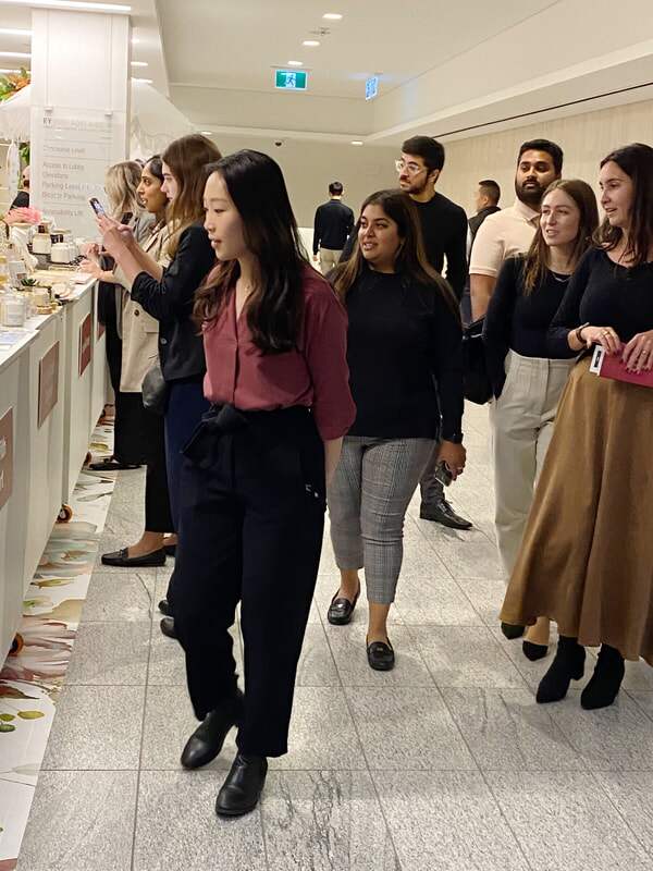 Shoppers browse a long row of vendor tables at an indoor pop-up market